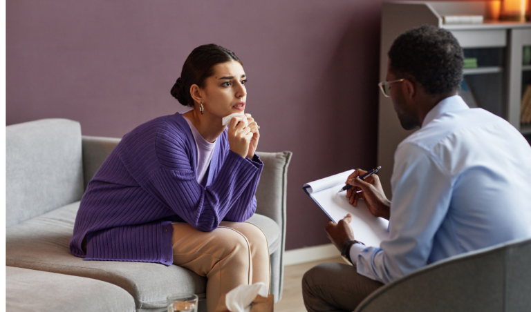 a woman sitting on a couch during a mental health therapy session with a therapist